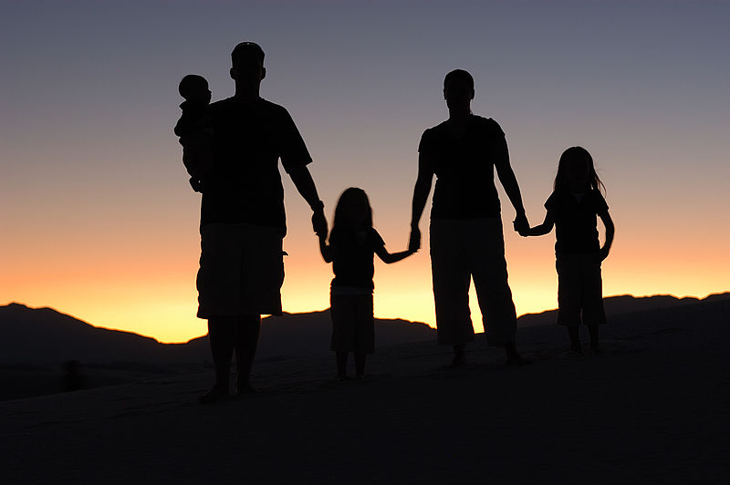 Silhouette of family in sunrise, home for good.