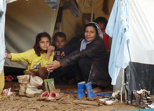 family in Syria sitting on muddy ground